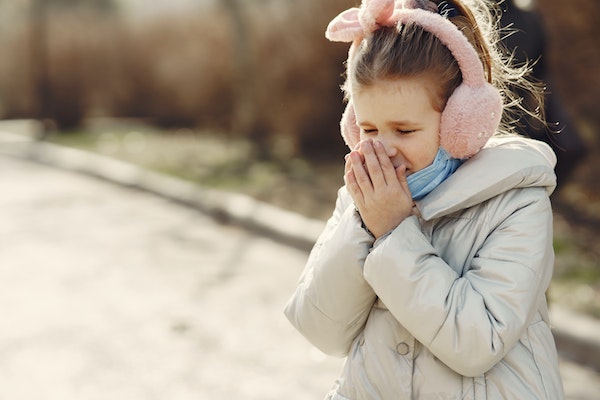 child sneezing to represent the importance of keeping your children warm