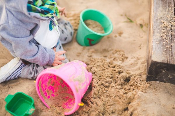 Little boy with buckets in the sand