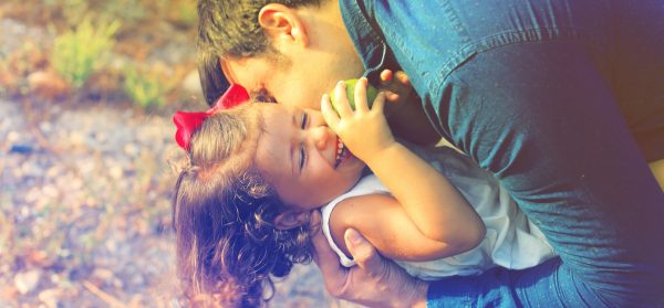 A father kissing his daughter on the cheek