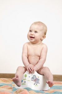 A baby sitting on the potty