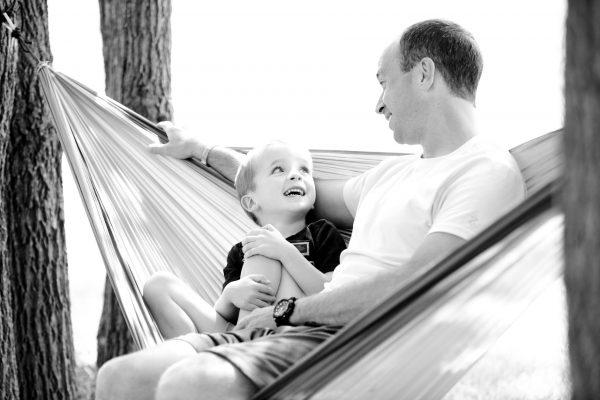 A dad talking to his son on a hammock
