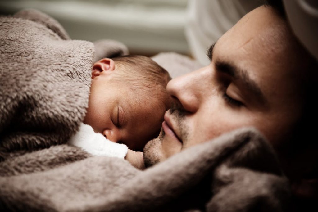 a father with his baby lying on his chest