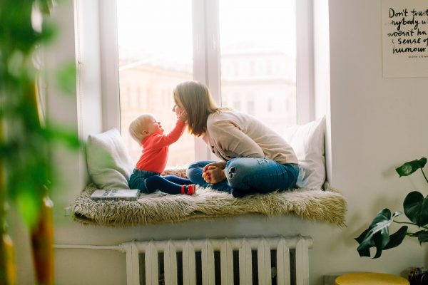 a little boy holding his mother's face to represent how to teach your child kindness