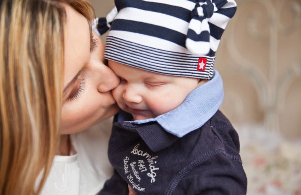 A mother kissing her baby