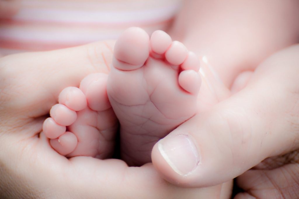 Hands cradling a baby's feet