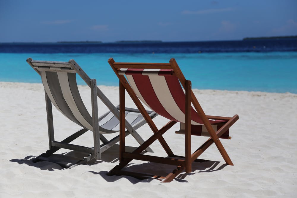 two deck chairs on the beach