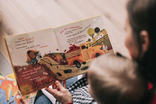 a mother reading a book with her toddler