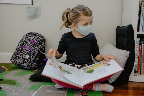 a little girl in school wearing a covid mask to represent parents dealing with separation anxiety