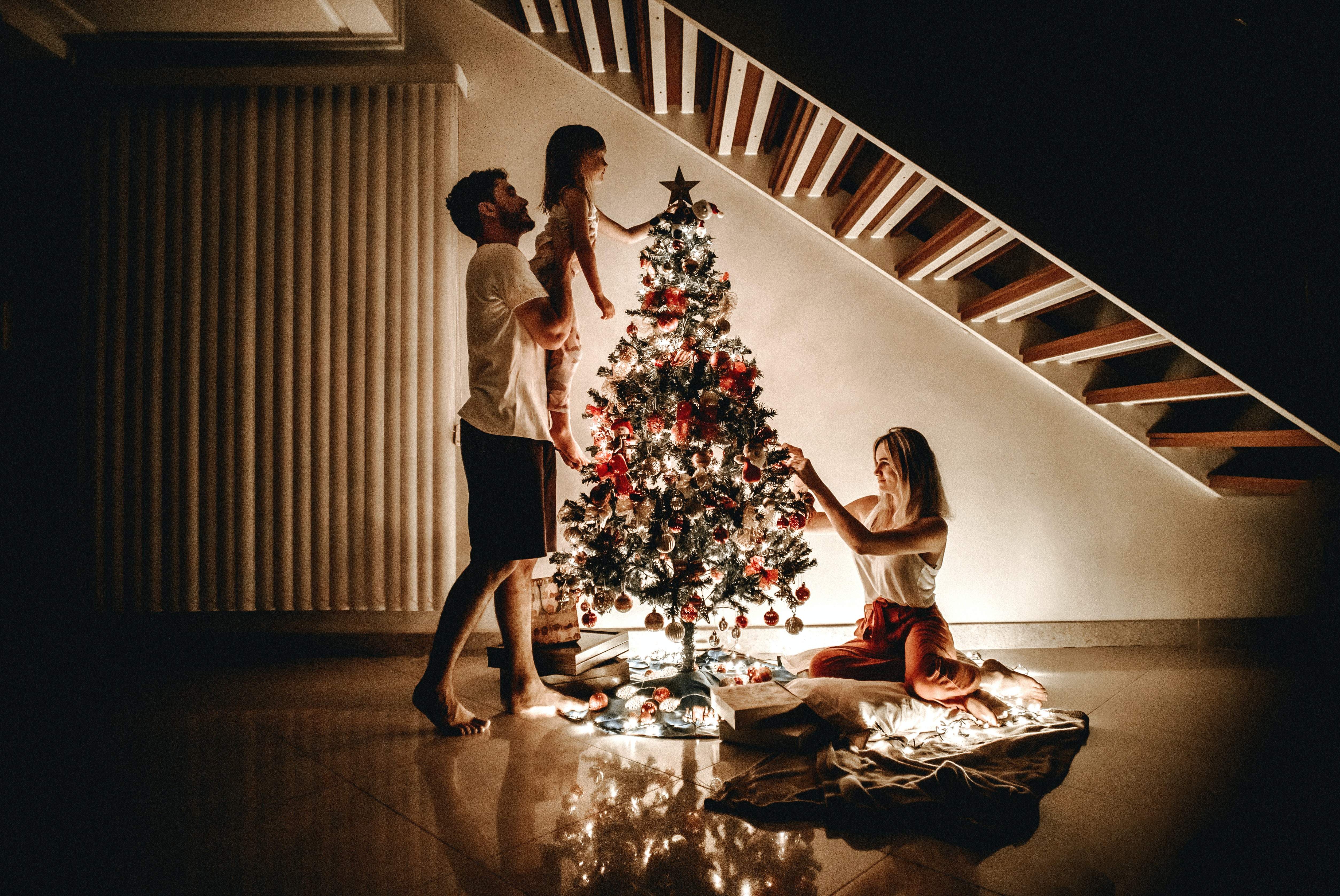 a family decorating a tree to represent how much do children need from Santa