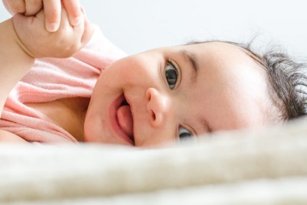 Smiling baby laying on their side 