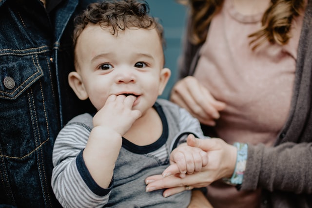 a toddler with his hand in his mounth to represent how to stop your child from biting