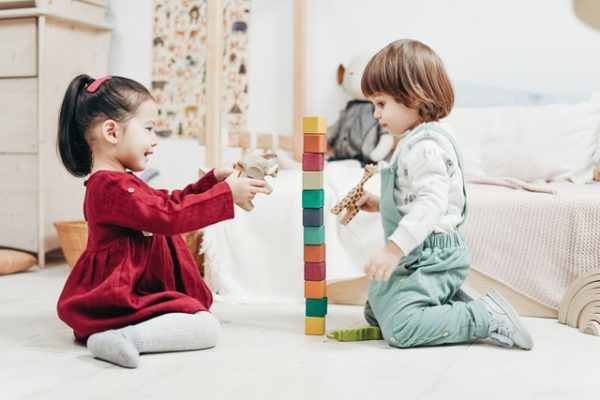 Two toddlers playing with building blocks to represent memories to make with your children