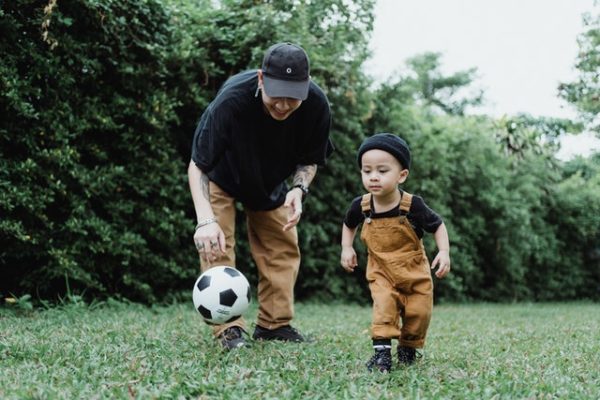 Father and son playing football to represent memories to make with your children