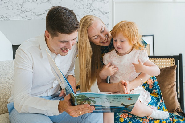 Parents and child reading to represent starting school