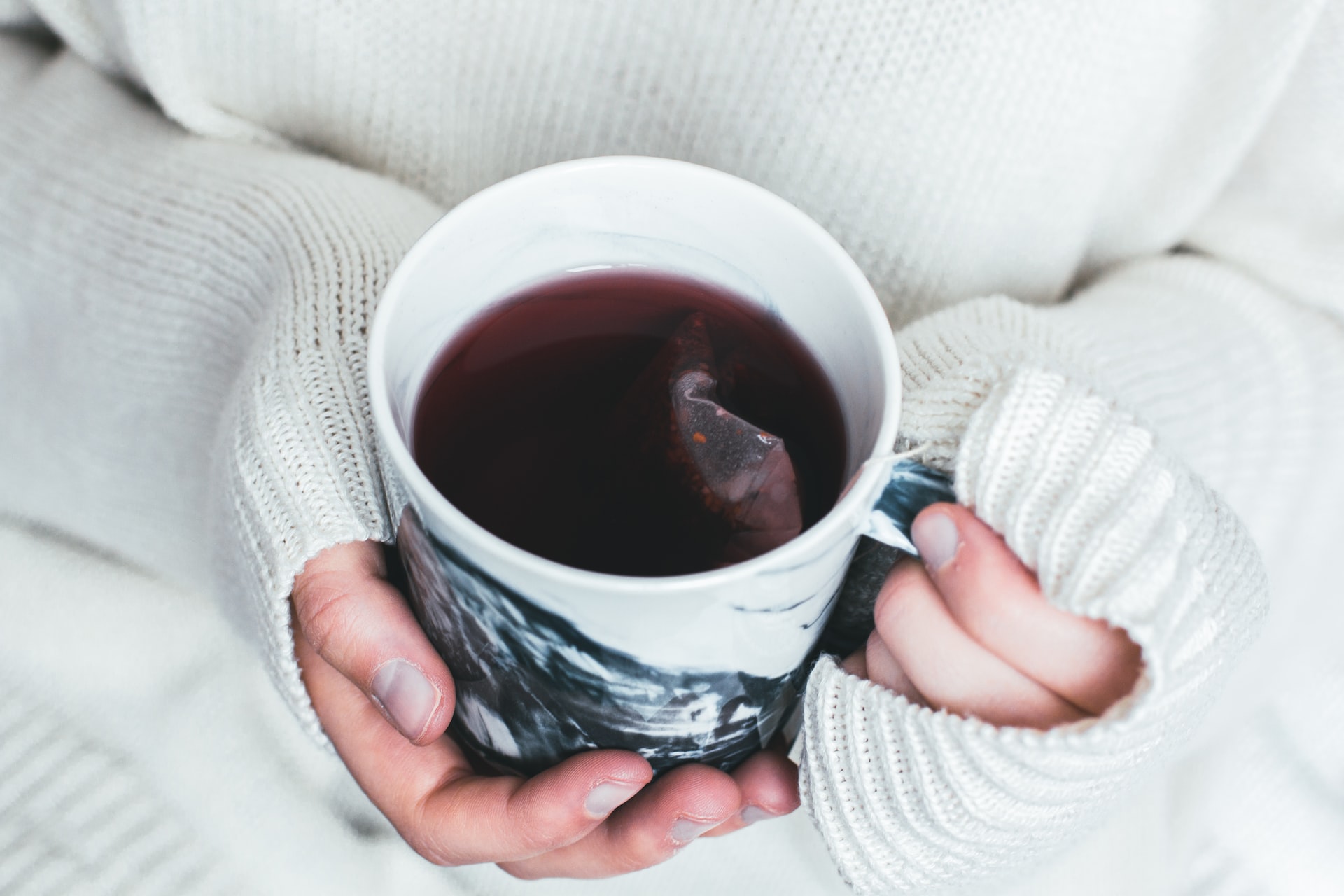 A person holding a cup of herbal tea to represent how to prioritise self-care as a parent