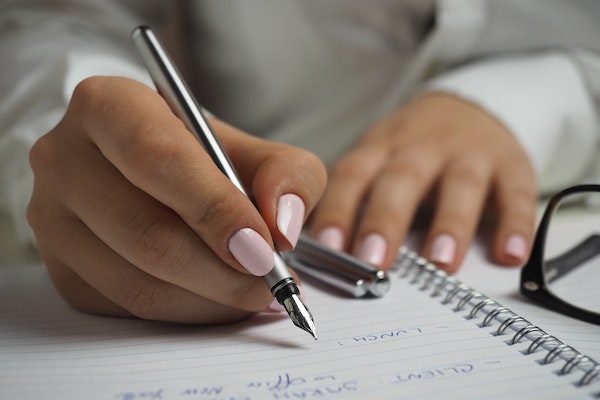 A woman writing a to-do list to represent how to switch off after work as a parent