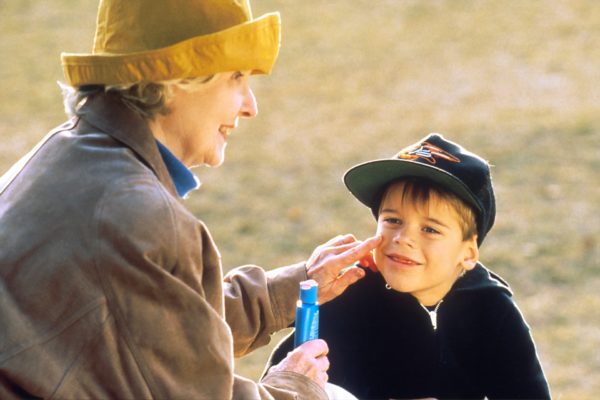 a grandma putting suncream on her grandson